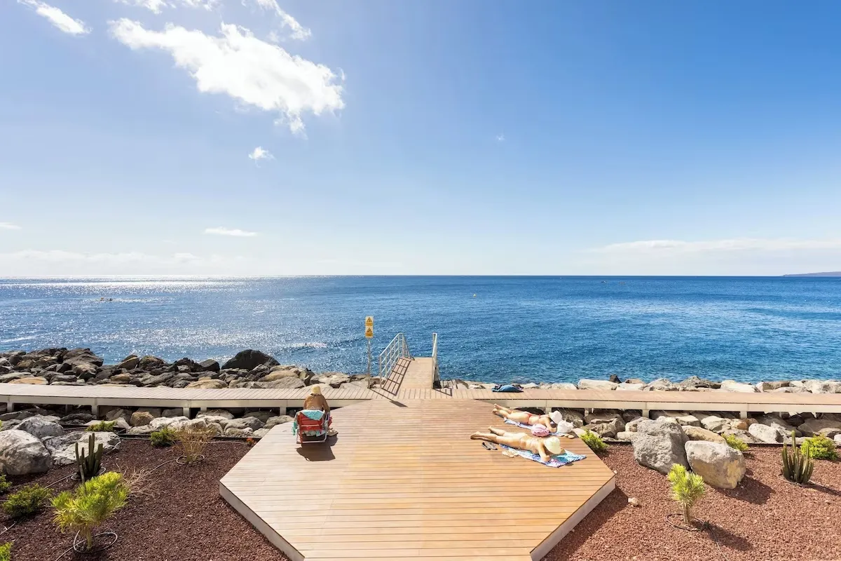 Wooden sun deck on the volcanic rocks, facing the open sea