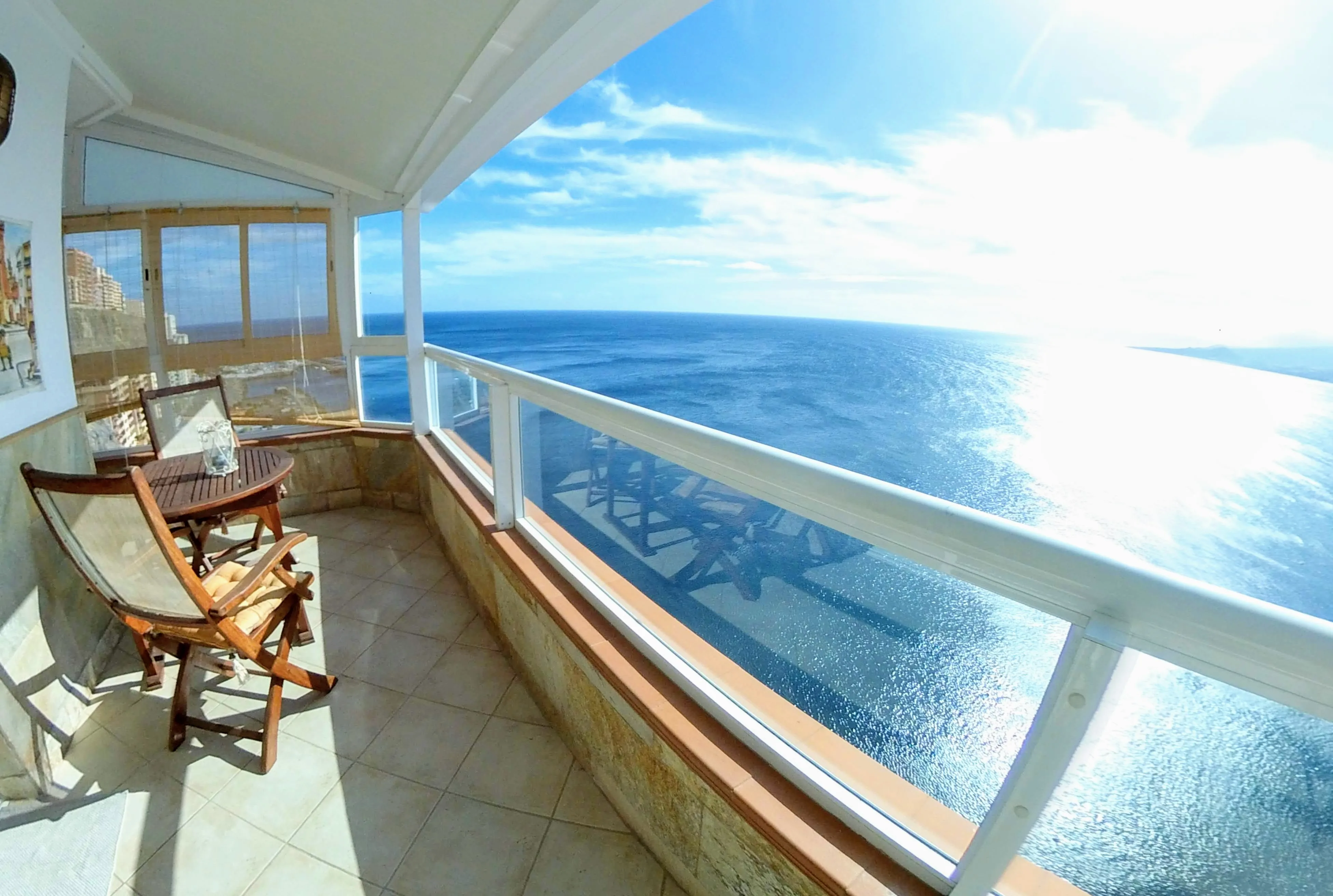 Terrasse de You & the Ocean ouverte sur l'Atlantique, table et fauteuils en bois